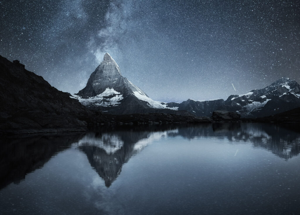 Swiss landscape. Matterhorn and reflection on the water surface at the night time. Milky way above Matterhorn, Switzerland. Travel image.