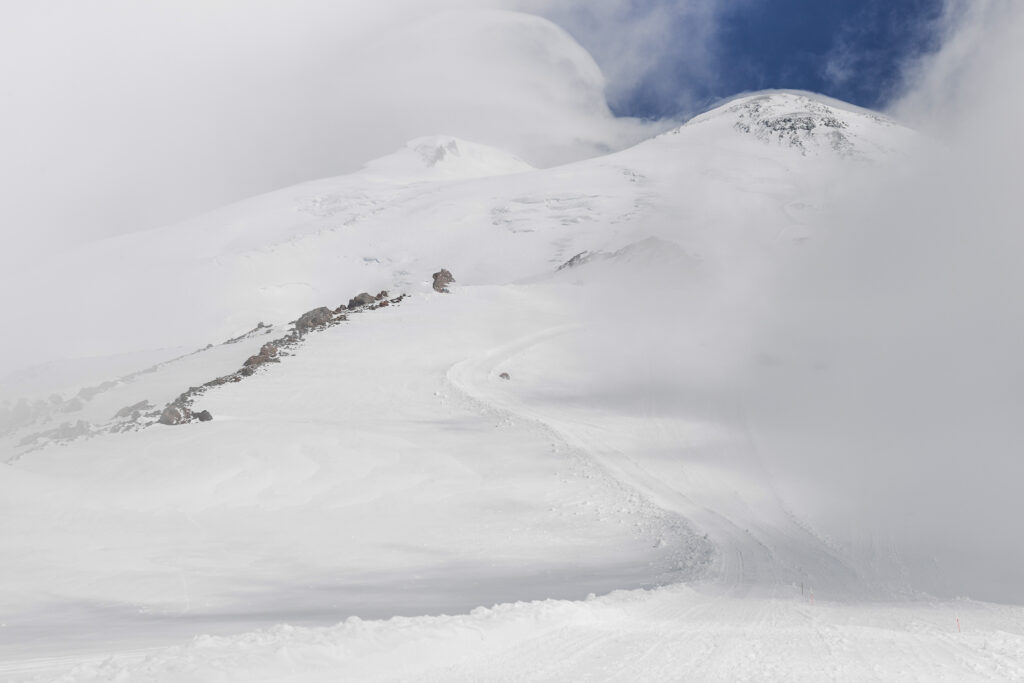 Panoramic view of two Elbrus peaks in snowy and foggy weather. Mountain hiking