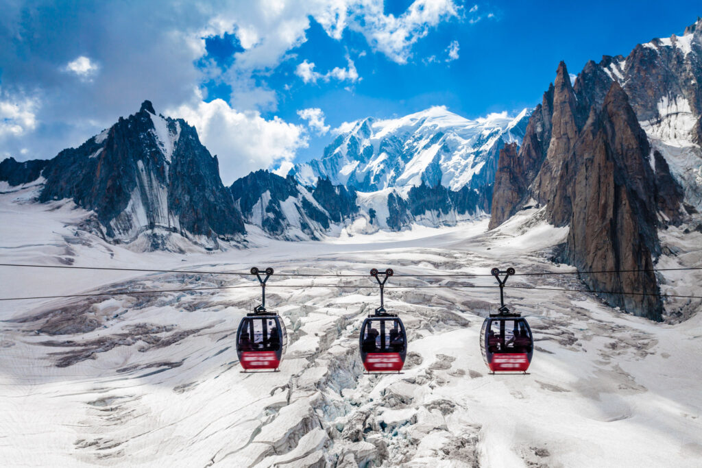 Elevated view of three cable cars over snow covered valley at Mont blanc, France
