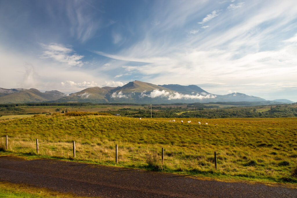 A scenic shot of the Ben Nevis mount and a field on its bottom in Scotland