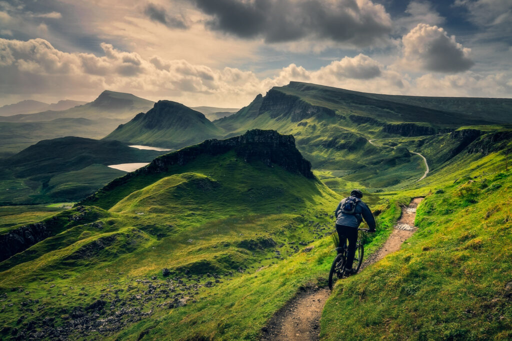 Mountain biker riding through rough mountain landscape of Quiraing, Isle of Skye, Scotland, UK