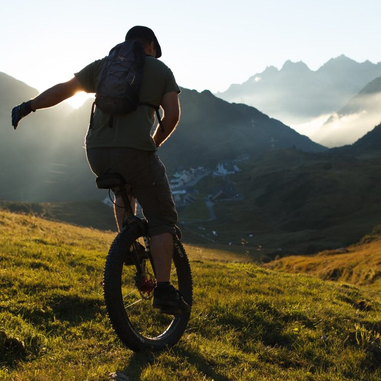 Mountain unicyclist on unicycle riding off-road