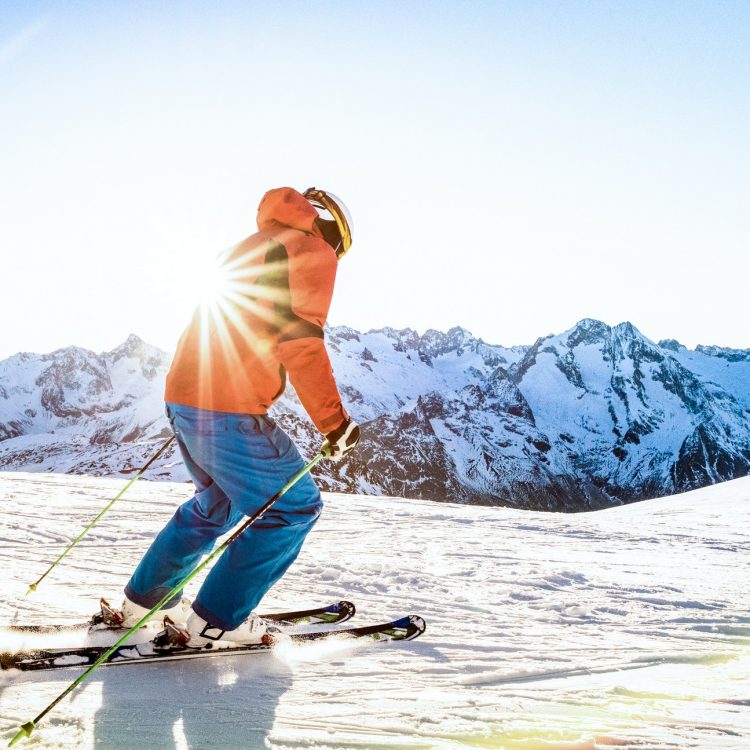 Professional skier athlete skiing at sunset on top of french alps ski resort